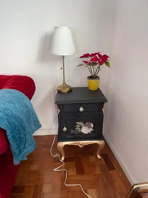 a nightstand with a lamp on it next to a bed at Apartamento Vintage 1 in Porto