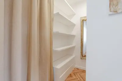 a bathroom with a shower curtain and shelves at Stylish Studio w/ Charming Terrace by HostWise in Porto