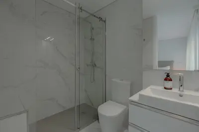 a kitchen with white cabinets and a black oven at Brand New Musas Ap by Best2Stay in Porto