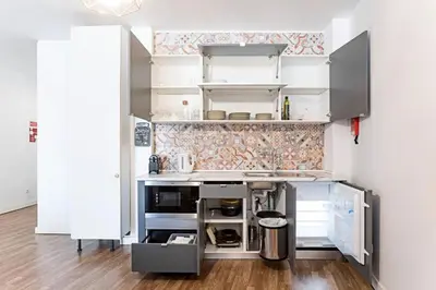 a small kitchen with white cabinets and a unintention at Coliseu Downtown Loft in Porto