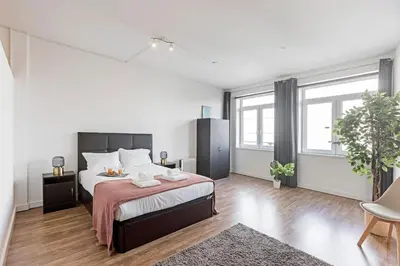 a bedroom with a large bed and some windows at Coliseu Downtown Loft in Porto