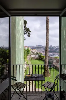 a patio with a table and chairs on a balcony at A House With A View - 1st floor in Porto