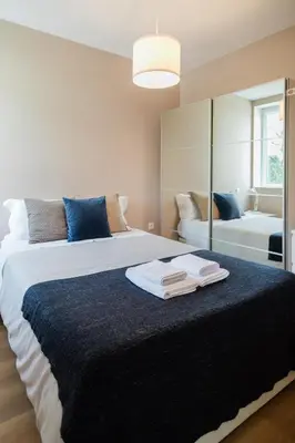 a bedroom with a large bed with towels on it at Downtown Refuge Camões in Porto