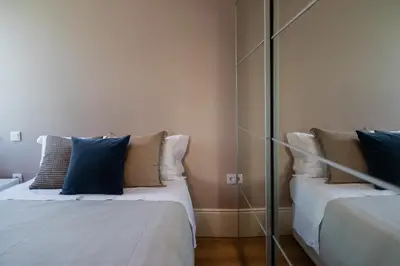 a room with two beds with pillows and a mirror at Downtown Refuge Camões in Porto