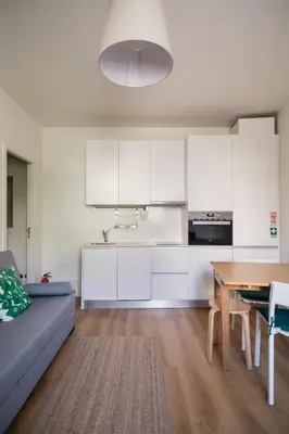 a kitchen and dining room with white cabinets and a table at Downtown Refuge Camões in Porto