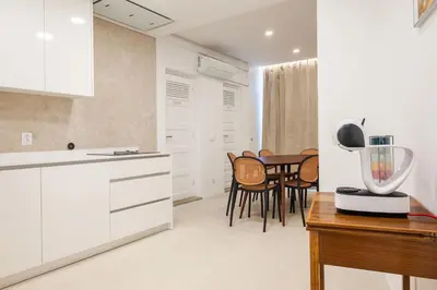 a kitchen with white cabinets and a table and chairs at Family Porto in Porto