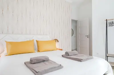 a bedroom with a white bed with two pillows on it at Family Porto in Porto