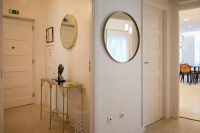 a hallway with a round mirror and a table at Family Porto in Porto