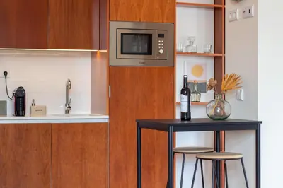 a kitchen with a table and a microwave at Miragaia Studio w Patio by LovelyStay in Porto