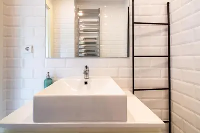 a white bathroom with a sink and a mirror at Miragaia Studio w Patio by LovelyStay in Porto