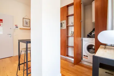 a kitchen and a laundry room with a washer and dryer at Miragaia Studio w Patio by LovelyStay in Porto