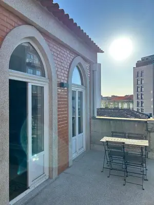 a patio with a table and a bench next to a building at Lazarus View Apartment in Porto