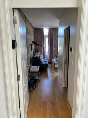 a hallway leading to a living room with a hard wood floor at Lazarus View Apartment in Porto