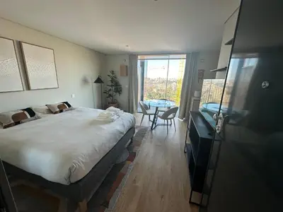 a bedroom with a bed and a table and a window at New Douro 908 with parking in Vila Nova de Gaia