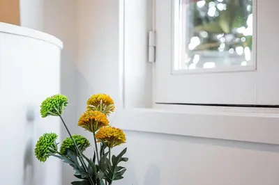 a vase with yellow flowers sitting next to a window at GuestReady - Oporto Old Town House 1 in Porto