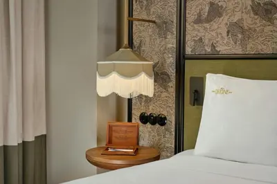 a bedroom with a bed and a table with a lamp at Origine Porto Gaia, a Tribute Portfolio Hotel in Vila Nova de Gaia