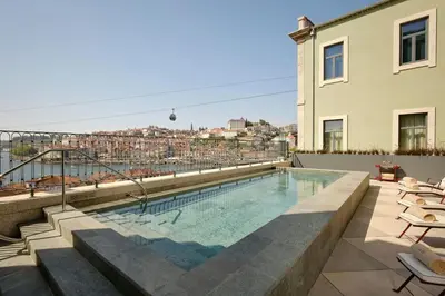 a bedroom with a large white bed and a balcony at Origine Porto Gaia, a Tribute Portfolio Hotel in Vila Nova de Gaia