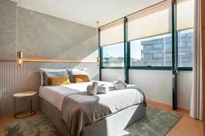 a bedroom with a bed with two teddy bears on it at DoisPontoZero Campo 24 Agosto in Porto