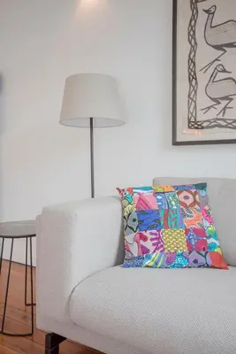 a living room with a couch and a table with a lamp at Liiiving in Porto - Downtown & Riverside Balcony in Porto