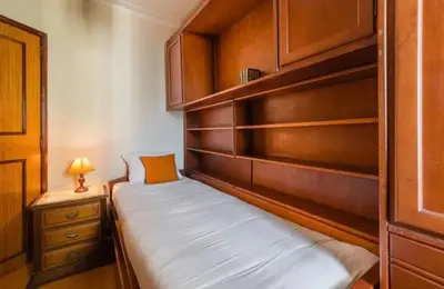 a small bedroom with a bed and wooden cabinets at Classic Charm of an Old Porto free parking in Vila Nova de Gaia