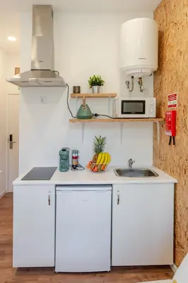a kitchen with white cabinets and a sink at HostWise - Stylish Sunny Flats in Porto