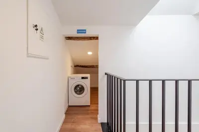 a hallway with a washing machine next to a staircase at HostWise - Stylish Sunny Flats in Porto