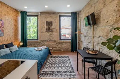 a bedroom with a bed and a table and a tv at HostWise - Stylish Sunny Flats in Porto