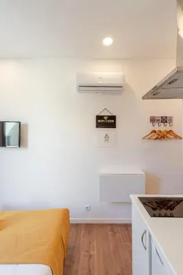 a bedroom with white walls and a yellow bed at HostWise - Stylish Sunny Flats in Porto