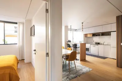 a room with a bed and a table and a kitchen at Yellow Breeze Apartment by Cozy Stay in Porto