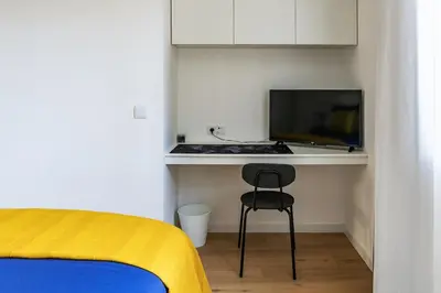 a bedroom with a desk with a laptop and a chair at Yellow Breeze Apartment by Cozy Stay in Porto