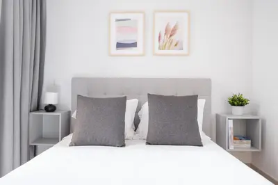 a bedroom with a white bed with two grey pillows at Ekaterine Uptown in Porto