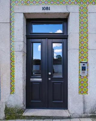 a black door on a building with a sign above it at Ekaterine Uptown in Porto