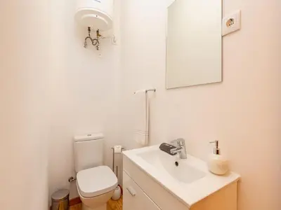 a bathroom with a toilet and a sink and a mirror at 2 Bedroom Apartment in Oporto in Porto