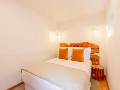 a bedroom with a white bed with orange pillows at 2 Bedroom Apartment in Oporto in Porto