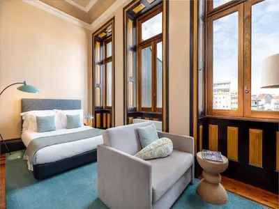 a room with a bed and a couch and a chair at Centrally located apartment in Oporto in Porto