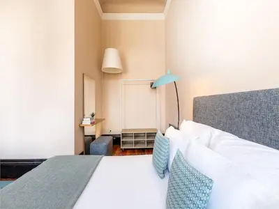 a bedroom with a white bed and a blue lamp at Centrally located apartment in Oporto in Porto
