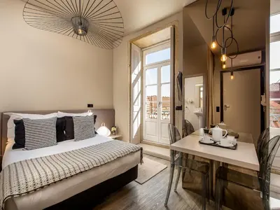 a bedroom with a bed and a table and a window at Apartment near picturesque Ribeira do Porto in Porto