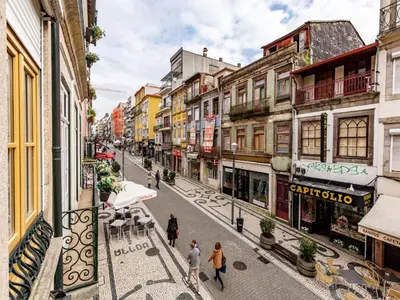 a group of people walking down a street with buildings at Centrally located apartment in Oporto in Porto