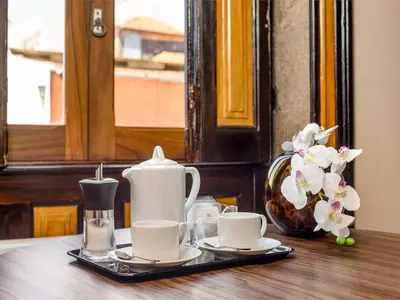 a table with coffee cups and a vase with flowers at Beautiful apartment in the heart of Oporto in Porto