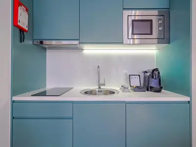 a kitchen with a sink and a microwave at Central Porto apartment with balcony in Porto