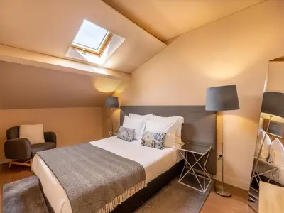 a bedroom with a bed and a chair at Beach studio nearby market in Oporto in Porto