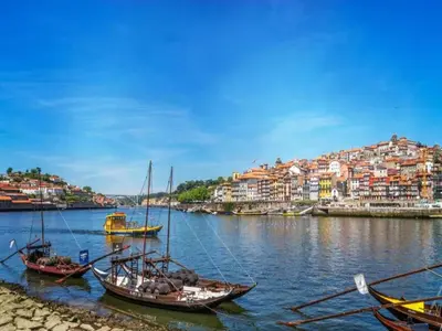 a group of boats in the water with a city at Beach studio nearby market in Oporto in Porto