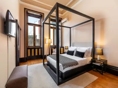 a bedroom with a four poster canopy bed at Beach studio nearby market in Oporto in Porto