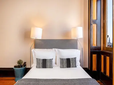 a bedroom with a white bed with two lamps at Beach studio nearby market in Oporto in Porto