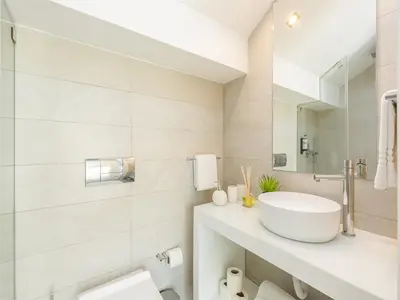 a white bathroom with a sink and a mirror at Spacious 4-Bedroom Apartment in Porto in Porto