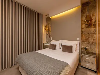 a bedroom with a bed with white sheets and pillows at Apartment in Vila Nova de Gaia in Vila Nova de Gaia