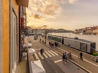 a group of people walking on a street next to the water at Apartment in Vila Nova de Gaia in Vila Nova de Gaia