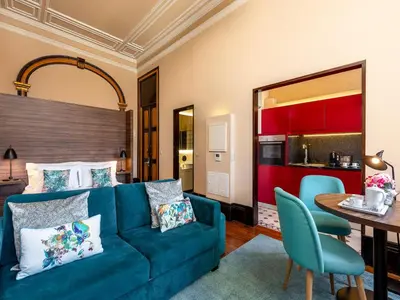 a living room with a blue couch and a table at Well-maintained air conditioned studio in Porto in Porto