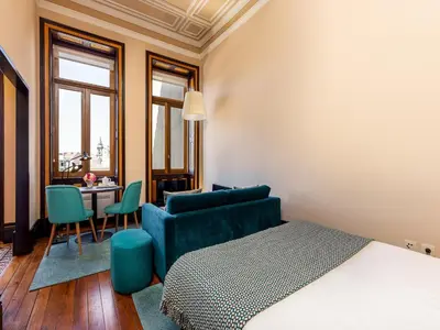 a room with a bed and a couch and a table at Well-maintained air conditioned studio in Porto in Porto