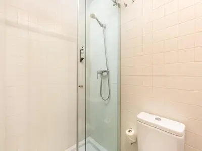 a white bathroom with a shower and a toilet at Charming 1-Bedroom Apartment in Oporto in Porto
